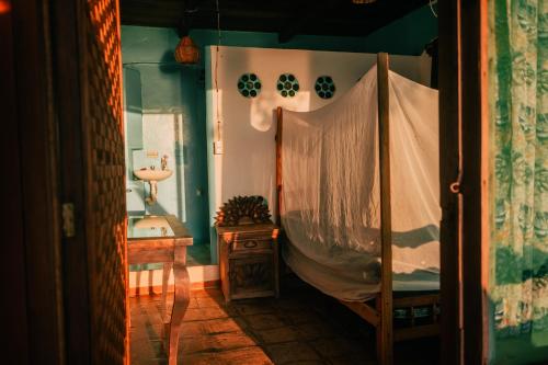 a bedroom with a bed and a table and a sink at Balamjuyuc Cabañas y Ecohostel in Santa María Tonameca