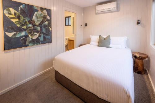 a bedroom with a white bed and a painting at BIG4 Wye River Holiday Park in Wye River