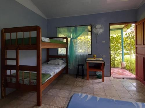 a bedroom with two bunk beds and a desk at Hospedaje Meryscar in Tortuguero