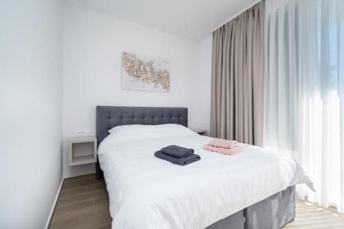 a bedroom with a bed with two towels on it at Family friendly house with a swimming pool Bibinje, Zadar - 23364 in Bibinje