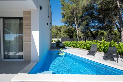 a swimming pool with two chairs and a toy in a house at Family friendly house with a swimming pool Bibinje, Zadar - 23363 in Bibinje