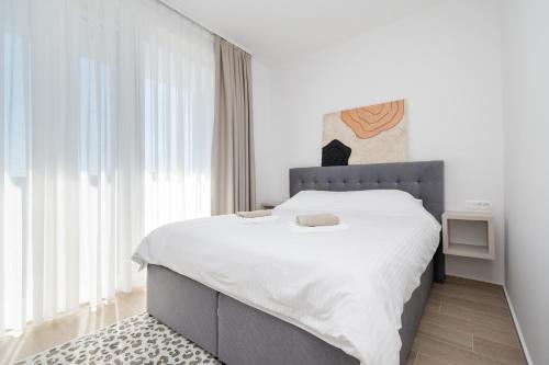 a bedroom with a large bed with white sheets at Family friendly house with a swimming pool Bibinje, Zadar - 23363 in Bibinje