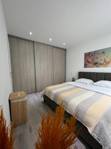 une chambre avec deux lits et un tableau au mur dans l'établissement Superbe appartement lumineux avec parking gratuit, à Wintzenheim