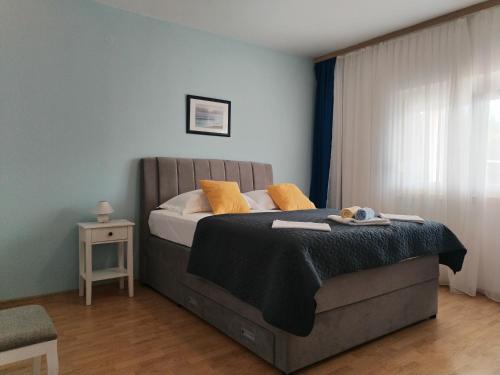 a bedroom with a bed with yellow pillows on it at Apartments Gvacic in Rab