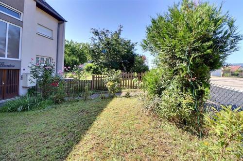 a yard of a house with a fence at Superbe appartement lumineux avec parking gratuit in Wintzenheim