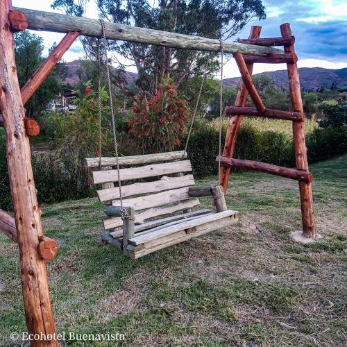 a wooden swing sitting in a field at Ecohotel Buenavista in Villa de Leyva