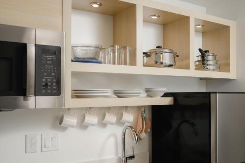 a kitchen with a microwave and some cups and dishes at TownePlace Suites by Marriott Chattanooga South, East Ridge in Chattanooga