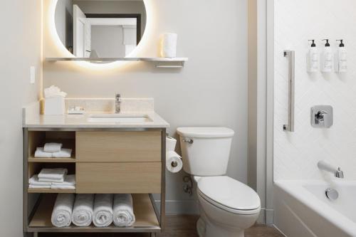 a bathroom with a toilet and a sink and a mirror at TownePlace Suites by Marriott Chattanooga South, East Ridge in Chattanooga