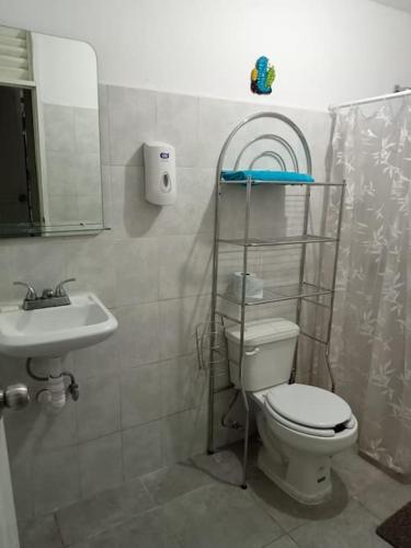 a bathroom with a toilet and a sink at Cozy House with Pool and AC Casa Armando in Cozumel