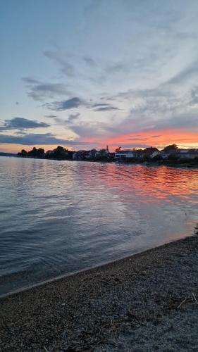 a body of water with a sunset in the background at Lakeview by Bea in Immenstaad am Bodensee