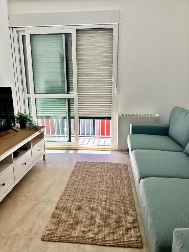 a living room with a couch and two large windows at Apartamento Estrellas de Mar in Ribeira