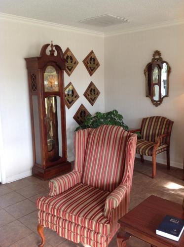 a living room with a couch and a grandfather clock at Ambassador Inn in Fayetteville