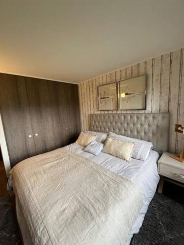a bedroom with a large bed with white sheets at Departamento Costa Pucón in Pucón