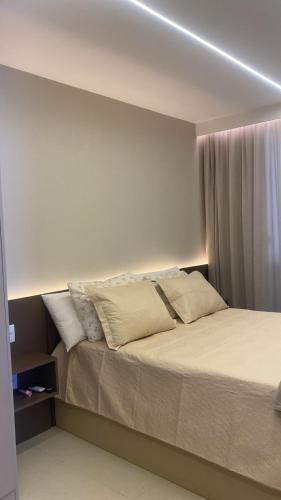 a bedroom with a large bed with pillows at Lindo Village 3 suítes Imbassaí in Mata de Sao Joao