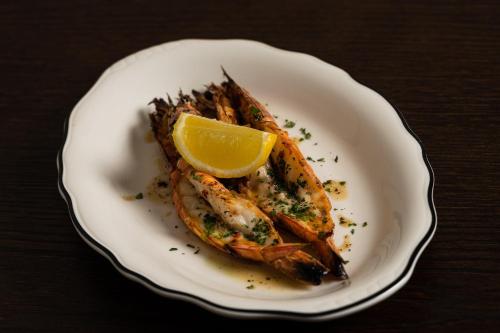 a plate of fish with a lemon on it at The Sebel Sydney Martin Place in Sydney