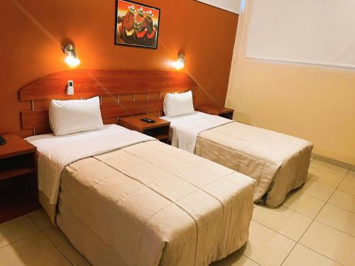a room with two beds in a hotel room at HOTEL Javier Prado Inn in Lima
