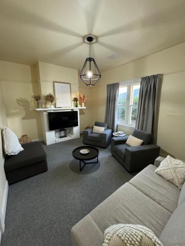 Una sala de estar con dos sofás y una chimenea. en 11Eardley - 2bedroom house - Free parking - 3 minutes from CBD, en Kings Park