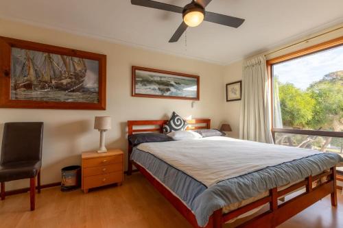 a bedroom with a large bed and a window at 25 Elizabeth Crescent in Carrickalinga