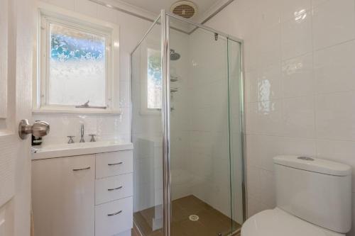 a bathroom with a shower and a toilet and a sink at 25 Elizabeth Crescent in Carrickalinga