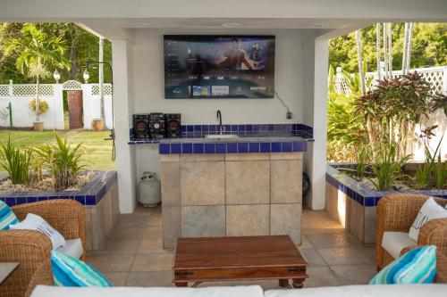 a patio with a kitchen with a tv on the wall at The Heart Villa, Exquisite Pool to Relax & Unwind in Golden Grove