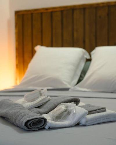 a bed with towels and a pair of shoes on it at Le Man Nima in Les Abymes