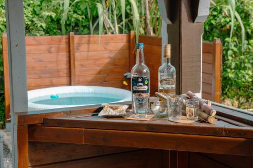 two bottles of alcohol sitting on a table next to a tub at Le Man Nima in Les Abymes