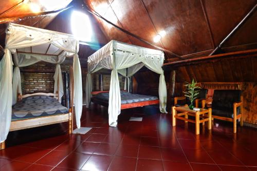a bedroom with two beds and a table and chairs at Bagus Bay Homestay in Tuktuk Siadong