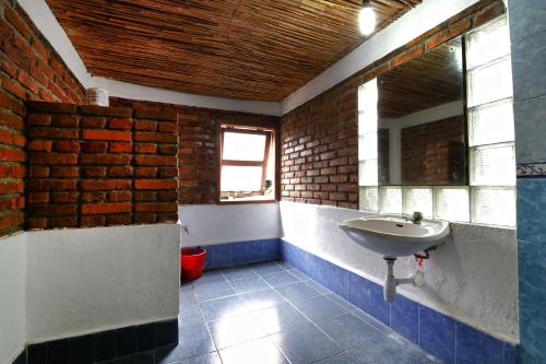 a bathroom with a sink and a brick wall at Bagus Bay Homestay in Tuktuk Siadong