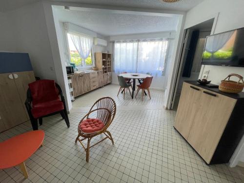 un salon avec une table et une chaise ainsi qu'une cuisine dans l'établissement Appartement T2 à Gruissan, RDC, Plage à 150m, Parking, 4-5 pers - FR-1-796-72, à Gruissan