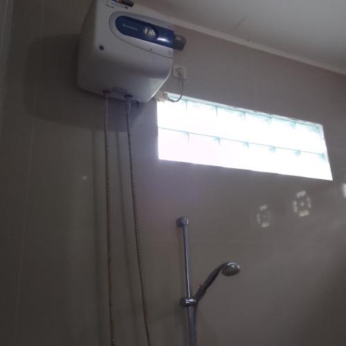 a window in a bathroom with a shower with a shower curtain at Shila Bungalow in Kelimutu