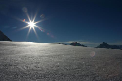 a sun is shining over a snow covered slope at Bacherhof in Sankt Anton am Arlberg