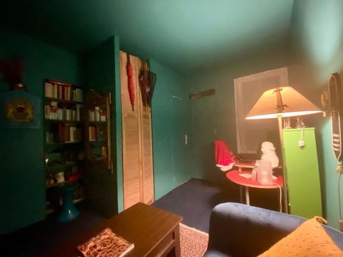 un salon avec une table, une chaise et une lampe dans l'établissement Appartement mignon et confortable avec accès jardin, à Paris