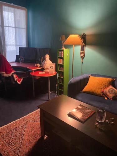 un salon avec un canapé et une table avec un ordinateur portable dans l'établissement Appartement mignon et confortable avec accès jardin, à Paris