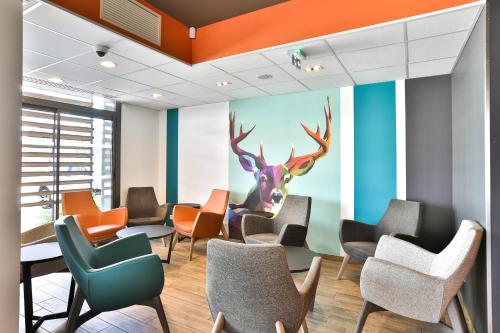 a waiting room with a mural of a deer on the wall at Kyriad Pontarlier in Pontarlier