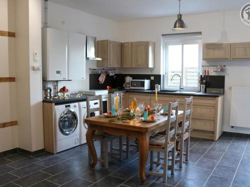 - une cuisine avec une table en bois, des chaises et un évier dans l'établissement Gîte typique Avesnois, familial avec terrasse, proche forêt et activités locales - FR-1-510-177, à Leval