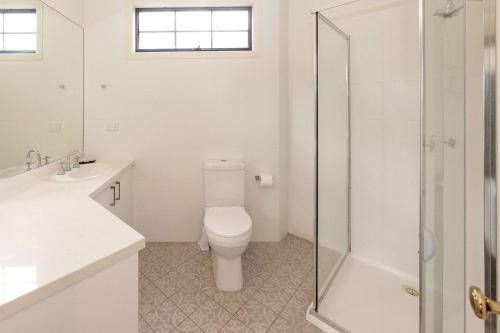 a white bathroom with a toilet and a shower at BIG4 Wye River Holiday Park in Wye River