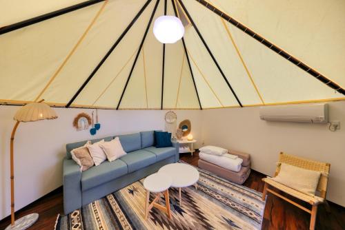 a living room with a blue couch and a table at Retreat Camp Mahoroba in Fujikawaguchiko