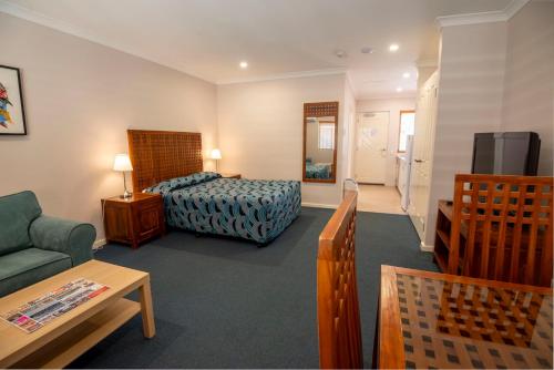 a hotel room with a bed and a couch at Bunbury Motel and Apartments in Bunbury