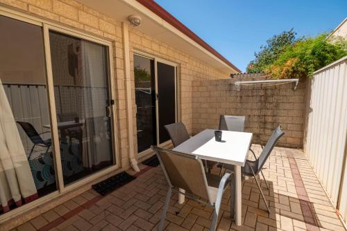 a patio with a white table and chairs at Bunbury Motel and Apartments in Bunbury