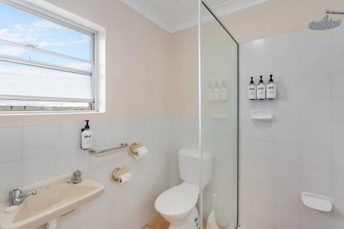 a white bathroom with a toilet and a sink at Econo Lodge Savannah Park Tamworth in Tamworth