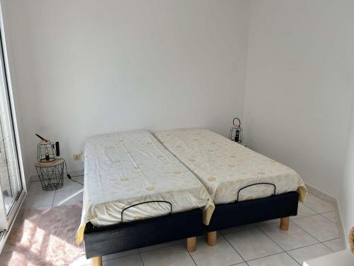 Ce lit se trouve dans un dortoir doté d'un mur blanc. dans l'établissement Appartement cosy à Port Fréjus: climatisé, proche plage, commerces et garage - 4 couchages - FR-1-226A-176, à Fréjus