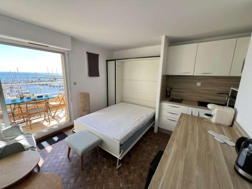Cet appartement comprend une chambre avec un lit et une cuisine avec un balcon. dans l'établissement Studio-Cabine 23m², Clim, Parking, Lave-Linge, Cap d'Agde - FR-1-702-67, au Cap d'Agde