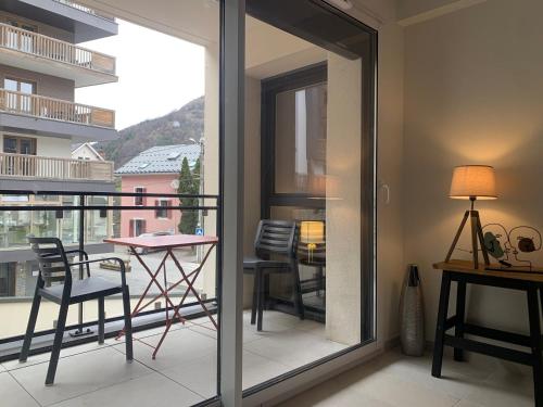 une chambre avec un balcon avec une table et des chaises dans l'établissement Appartement Neuf, 2 Pièces, Balcon, Parking, Proche Centre-Brides-les-Bains et Télécabine Olympe - FR-1-512-279, à Brides-les-Bains