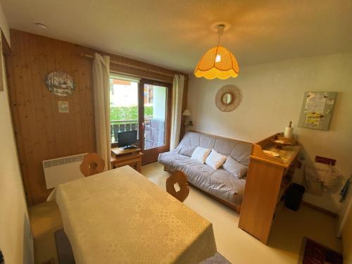 un salon avec un canapé et une table dans l'établissement Appartement cosy à Châtel - 4 pers, balcon, parking, proche télécabine, accès WIFI, animaux admis - FR-1-198-265, à Châtel