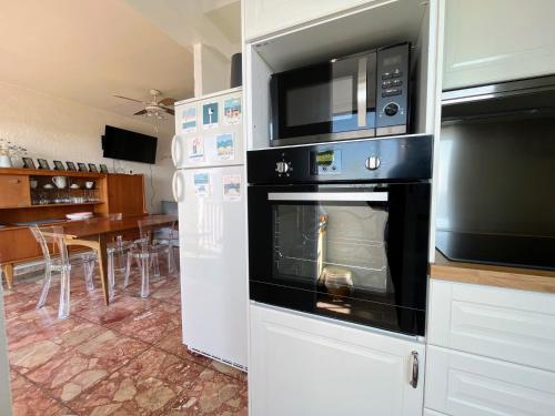 La cuisine est équipée d'un four et d'un four micro-ondes. dans l'établissement Charmant T2 à 200m de la plage et 100m des commerces, avec parking privatif - FR-1-309-474, à Saint-Cyprien