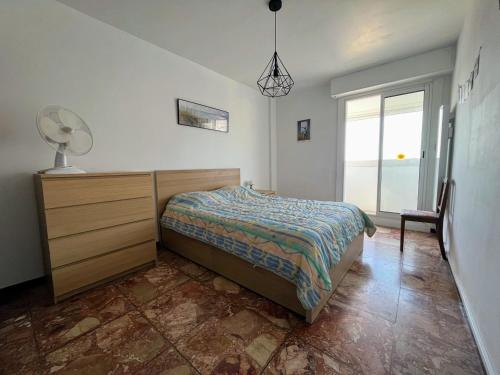 une chambre avec un lit, une commode et une fenêtre dans l'établissement Charmant T2 à 200m de la plage et 100m des commerces, avec parking privatif - FR-1-309-474, à Saint-Cyprien