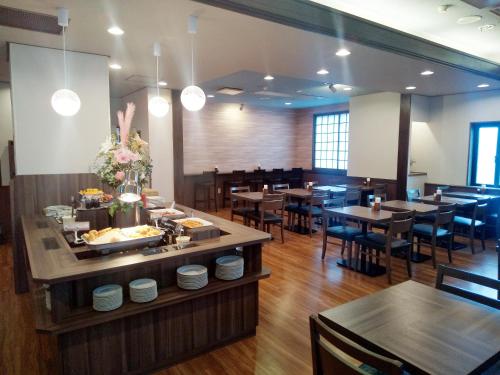 a restaurant with tables and chairs and a buffet at Hotel Route-Inn Court Chikuma-Koshoku in Chikuma