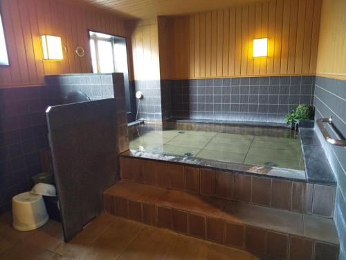 a large bathroom with a tub with a shower at Hotel Route-Inn Court Chikuma-Koshoku in Chikuma