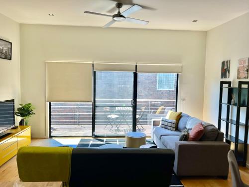 a living room with a couch and a tv at Ascot Vale - Lovely 2 bedroom townhouse close to everything! in Ascot Vale