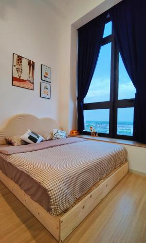 a bedroom with a large bed with a large window at Sunway Grid Loft Suite by Chill Lah Home in Iskandar Puteri